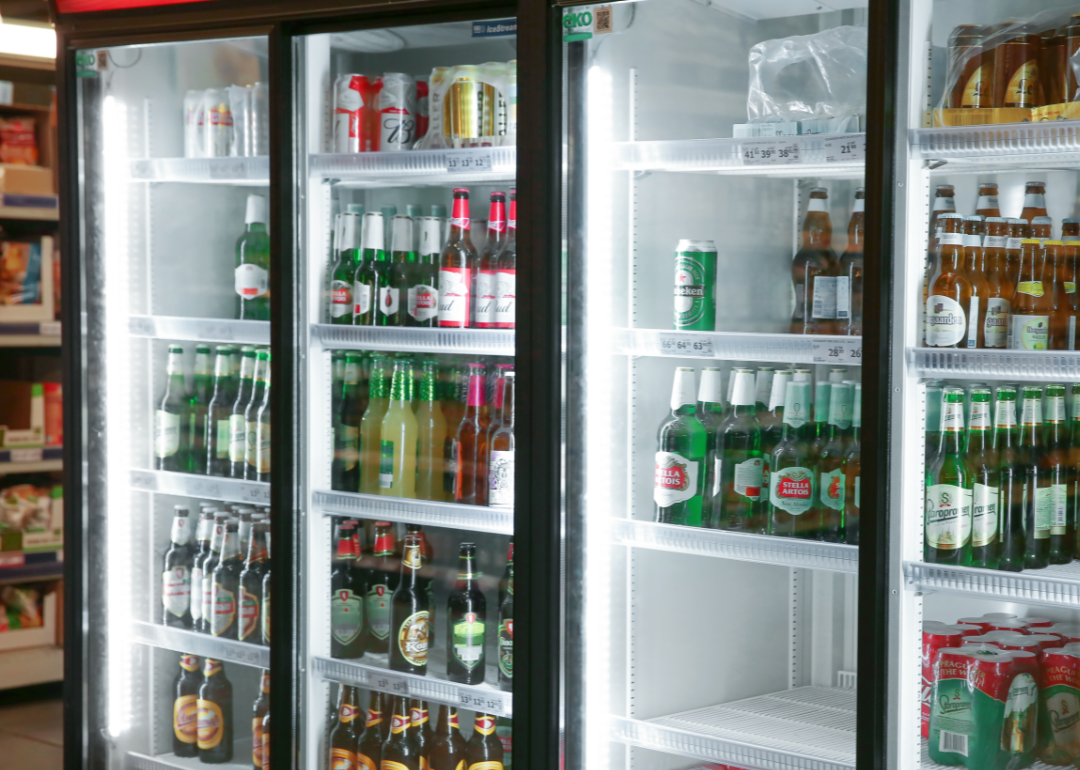 A variety of beers in a refrigerator in a supermarket.