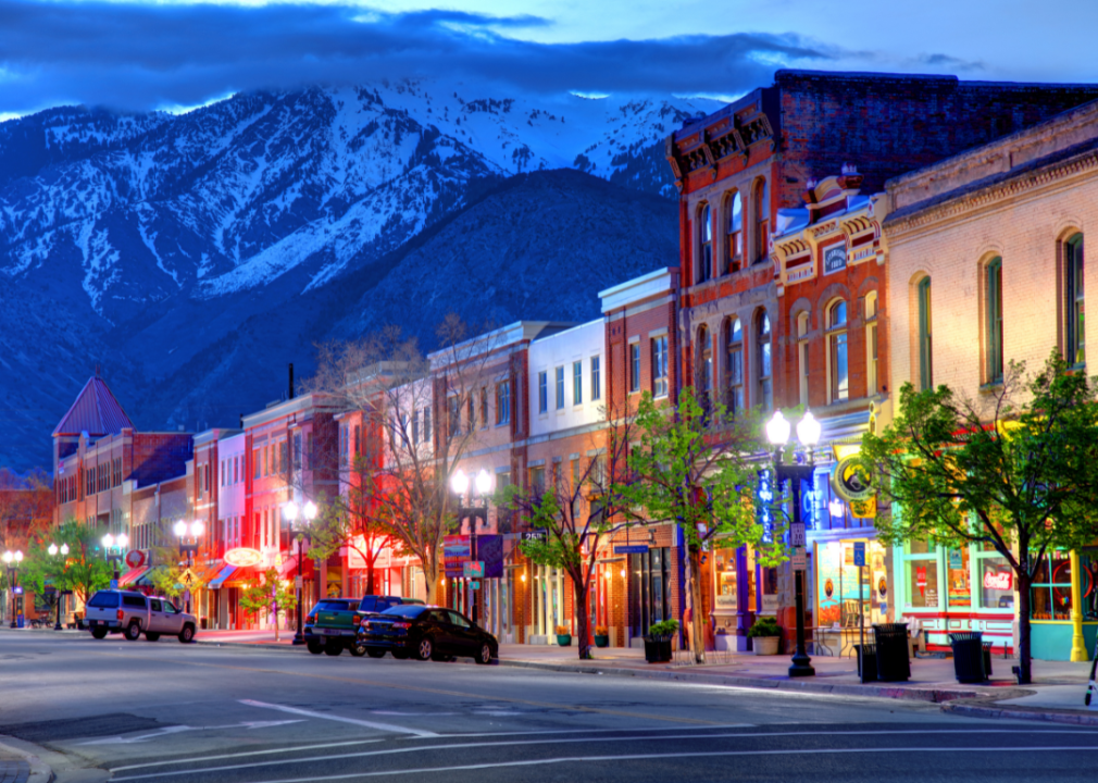 Colorful buildings at dusk in Ogden, Utah with snow-capped mountains in the distance.