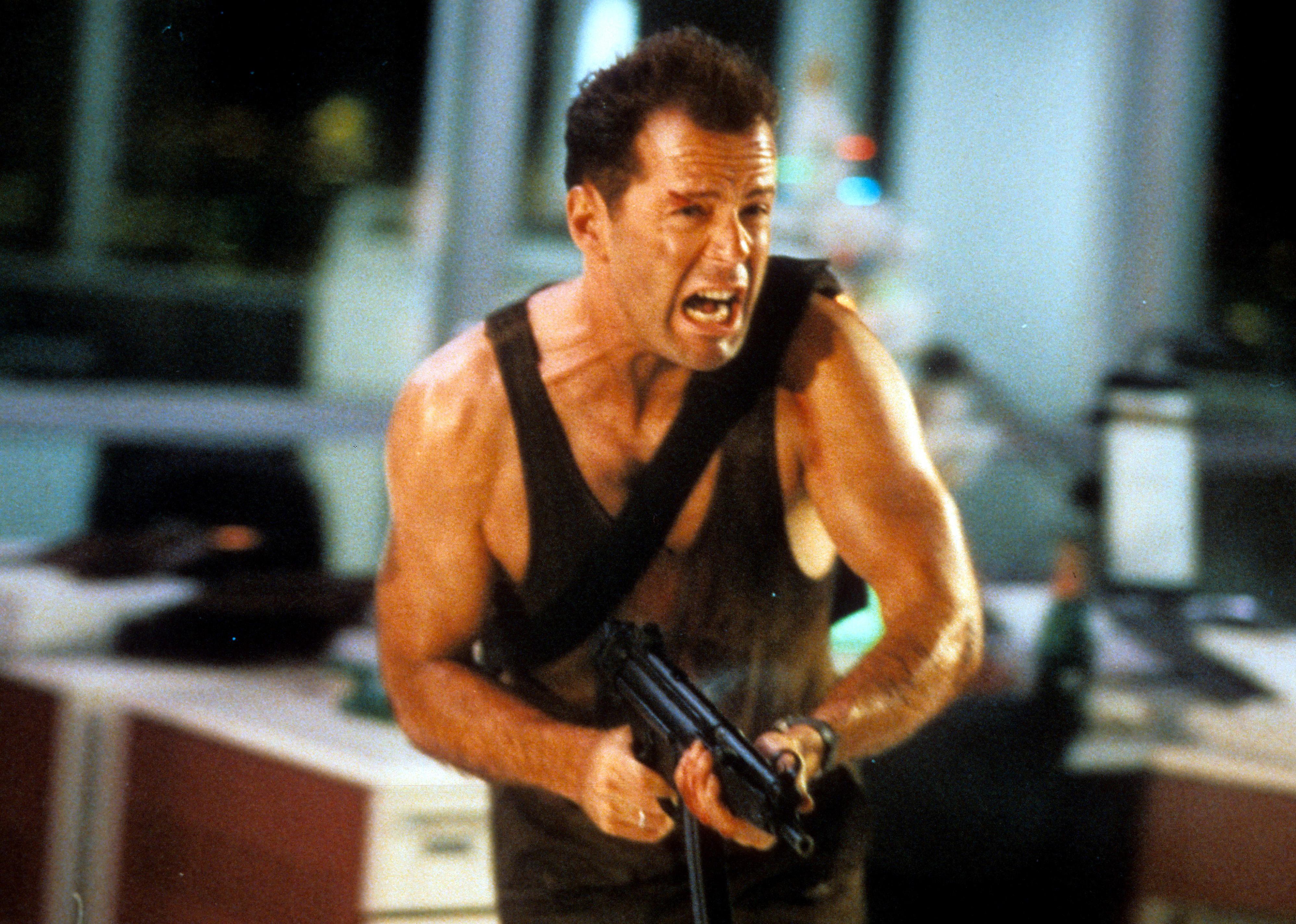 Bruce Willis running and screaming with a gun in his hands.