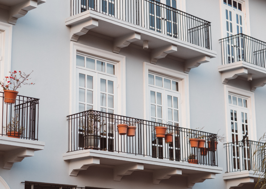 Light grey apartment building with white trim and black balconies.