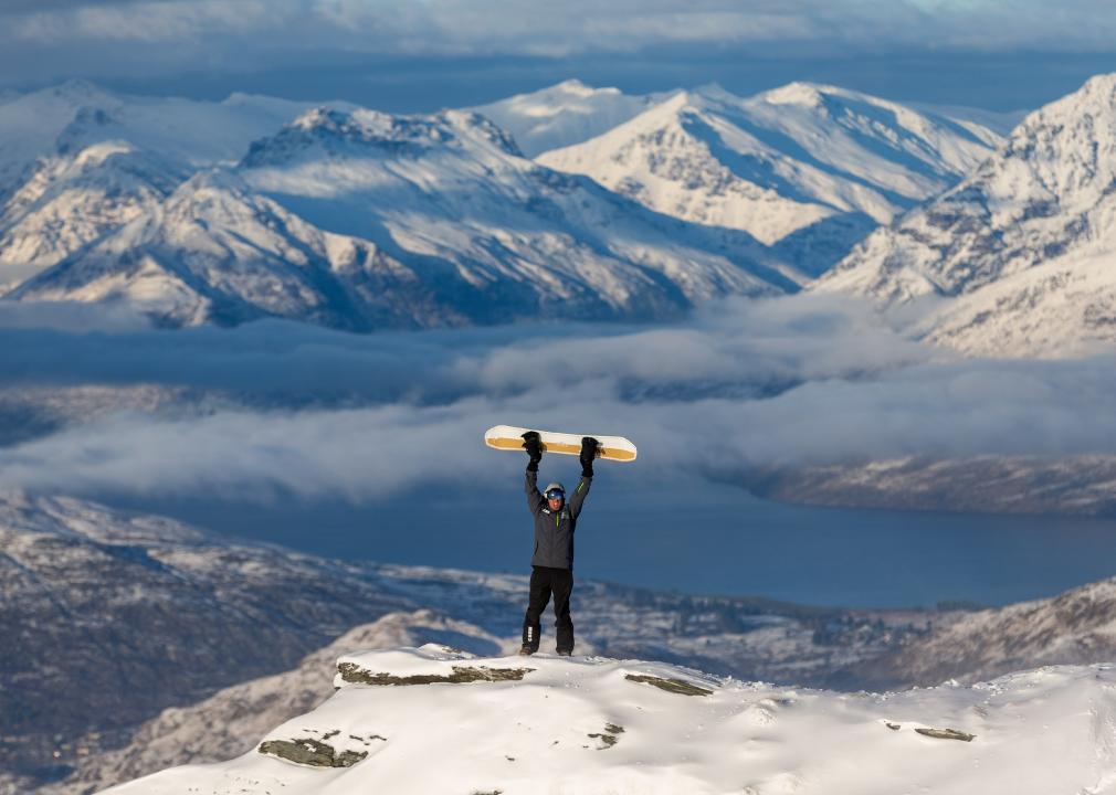 Social media influencer Kyle Mulinder holds up his snowboard on top of Coronet Peak on June 30, 2021 in Queenstown, New Zealand. 