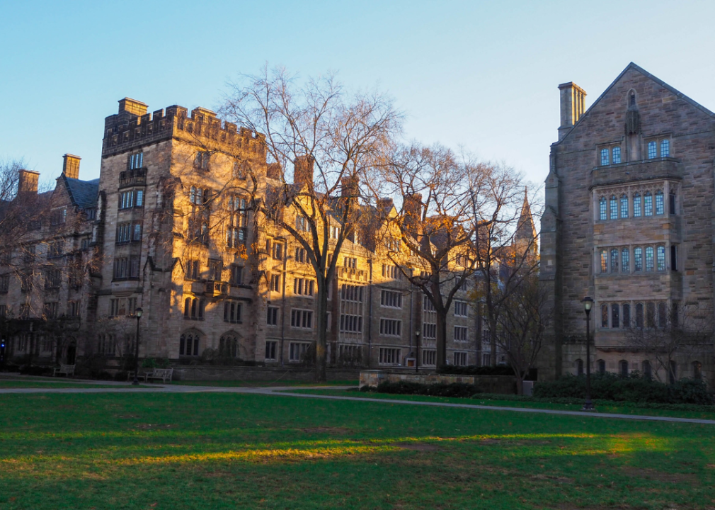Historic stone building and green grass at Yale University.