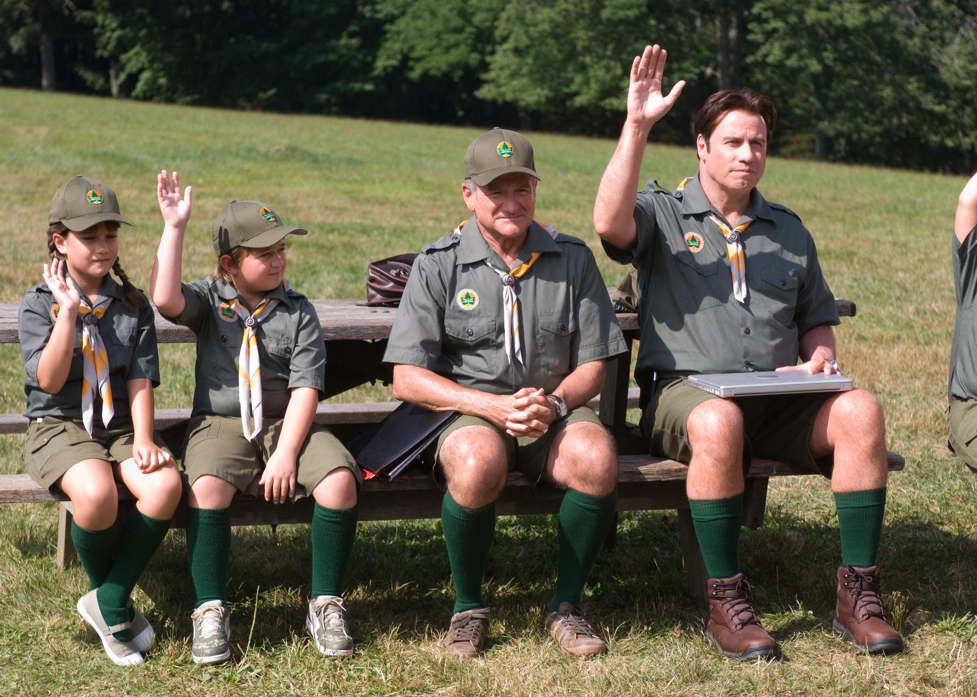 John Travolta, Robin Williams and two kids in green scout uniforms.