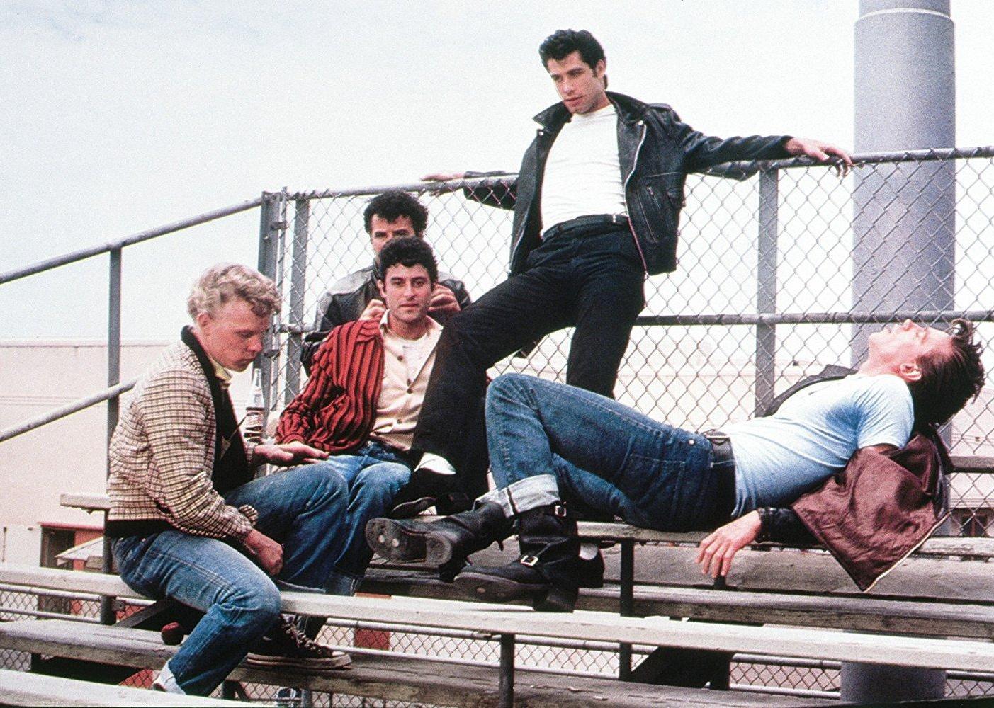John Travolta and his buddies hang out on the bleachers.