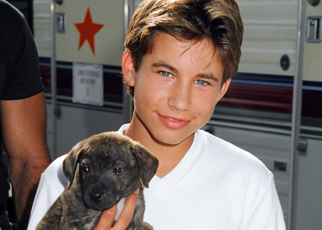 Jonathan Taylor Thomas holding a puppy.