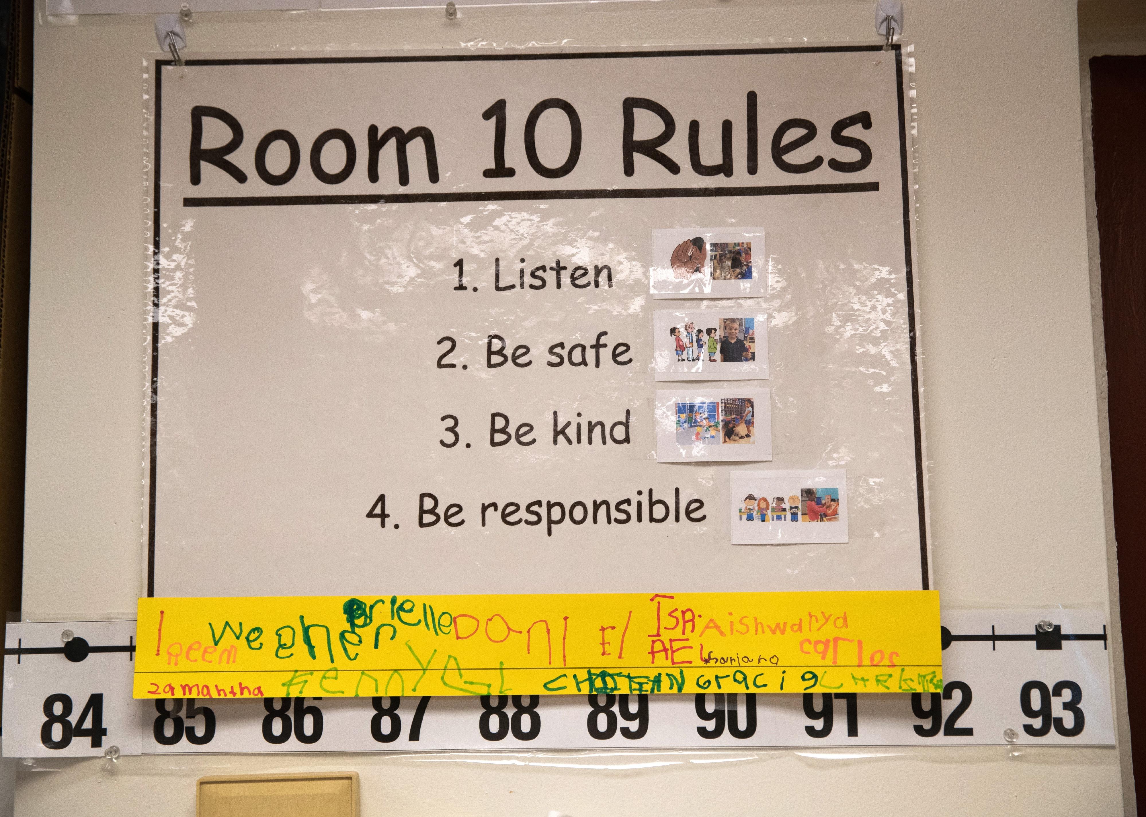 A sign in a class listing rules like Be Kind, Be Safe, Listena and Be Responsible.