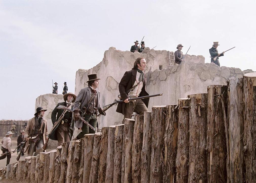 A group of men carrying rifles in the Old West.