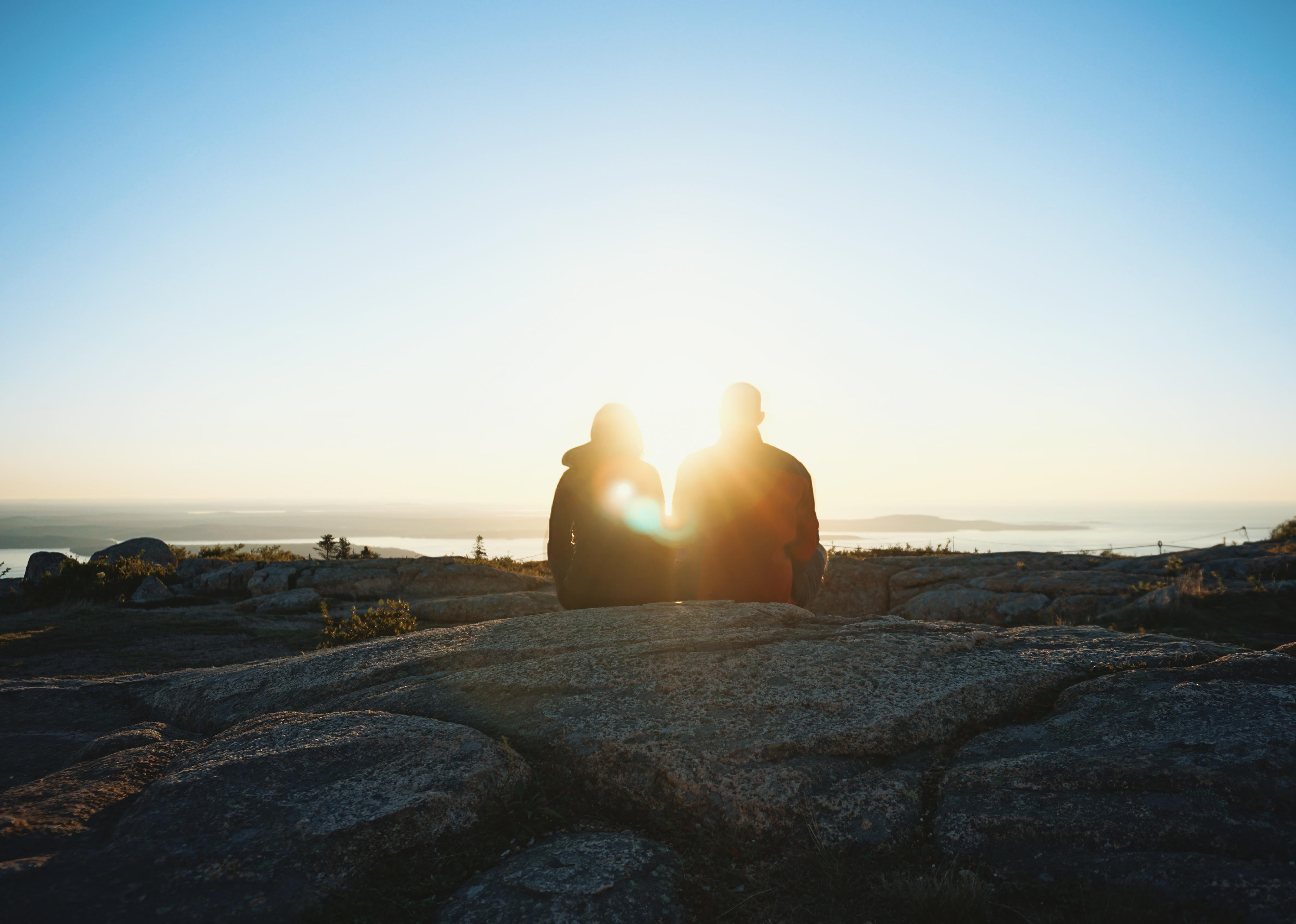 A couple watching the sunset in Maine.