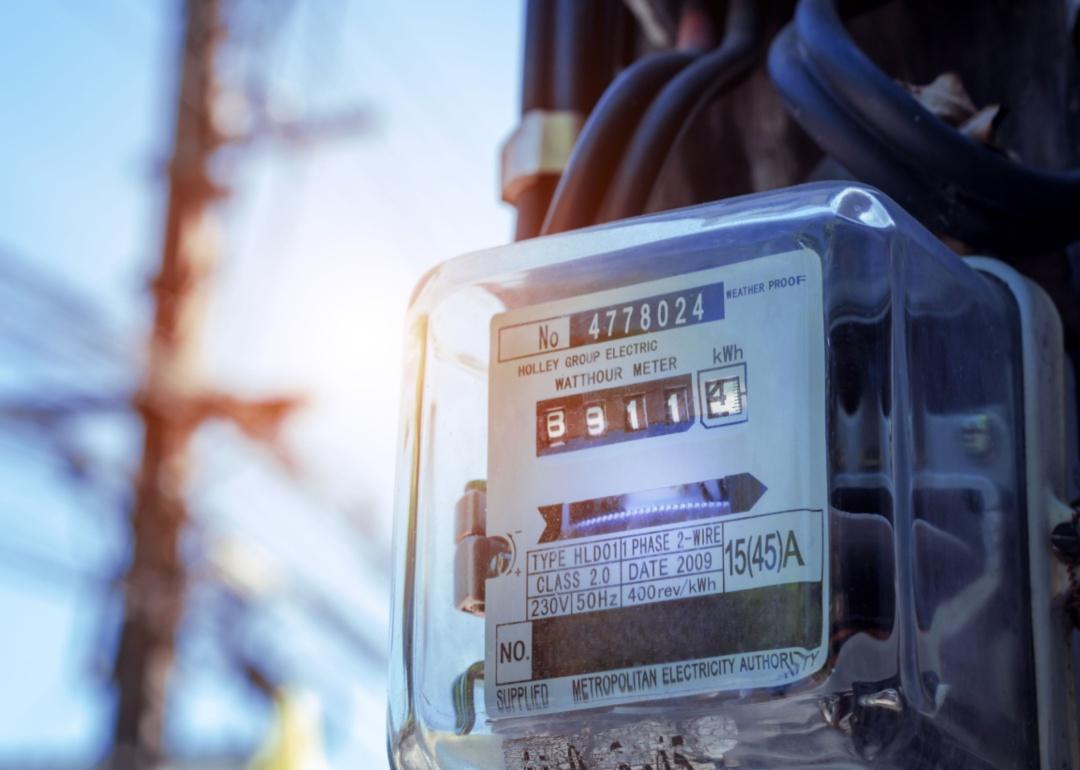 A square home electricity meter inside a clear weatherproof box.