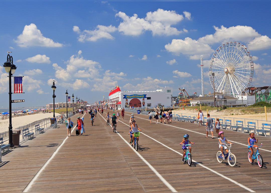 A ferris wheel and boardwalk with bikers in Ocean City.