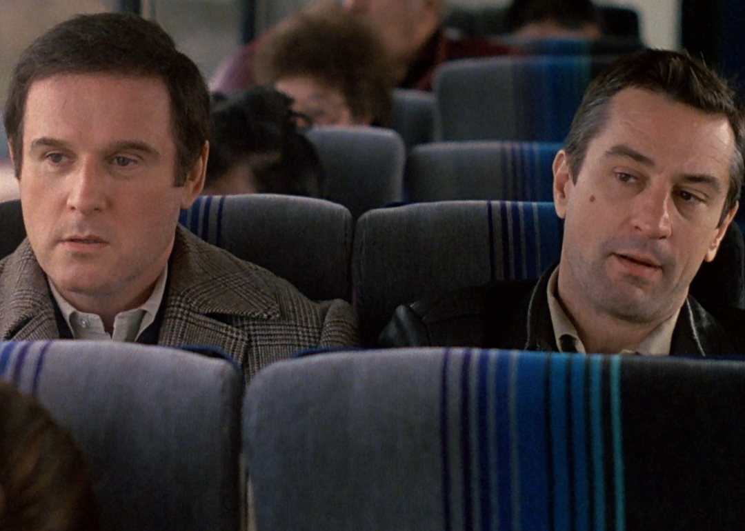 Robert DeNiro and Charles Grodin sitting on a bus together.