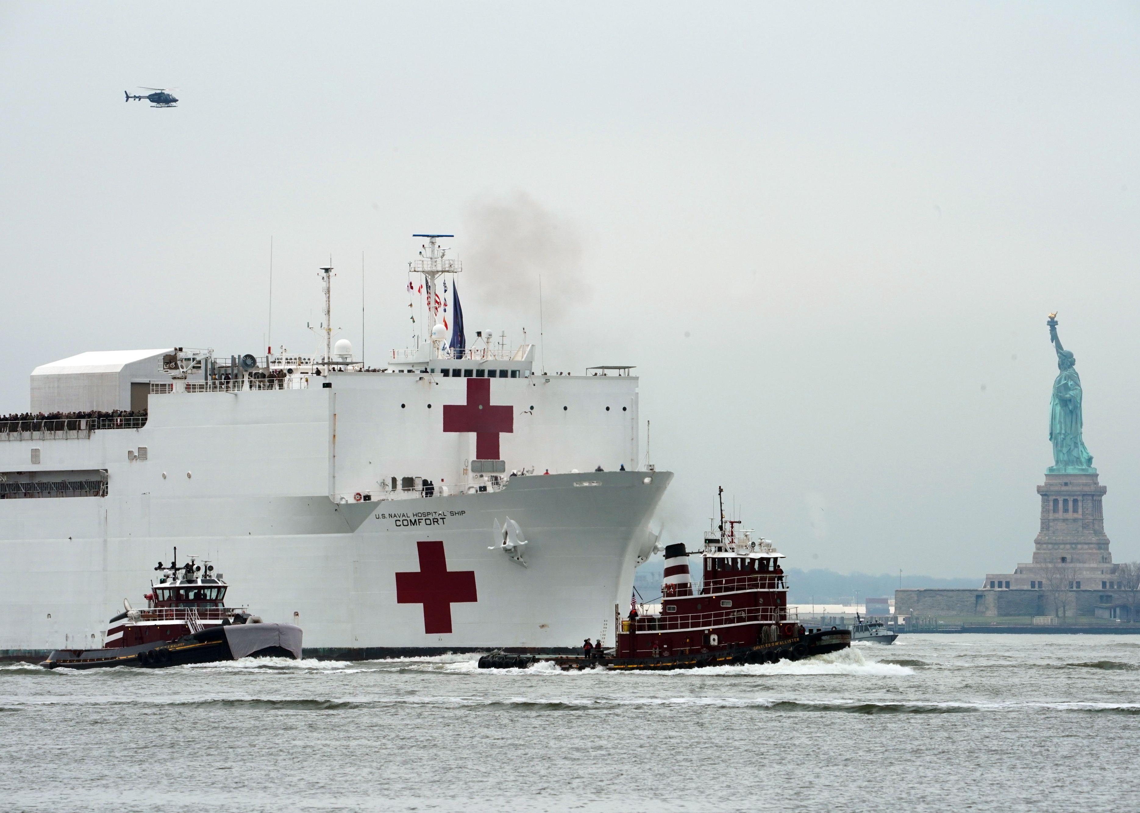 The USNS Comfort medical ship moving up the Hudson River past the Statue of Liberty.