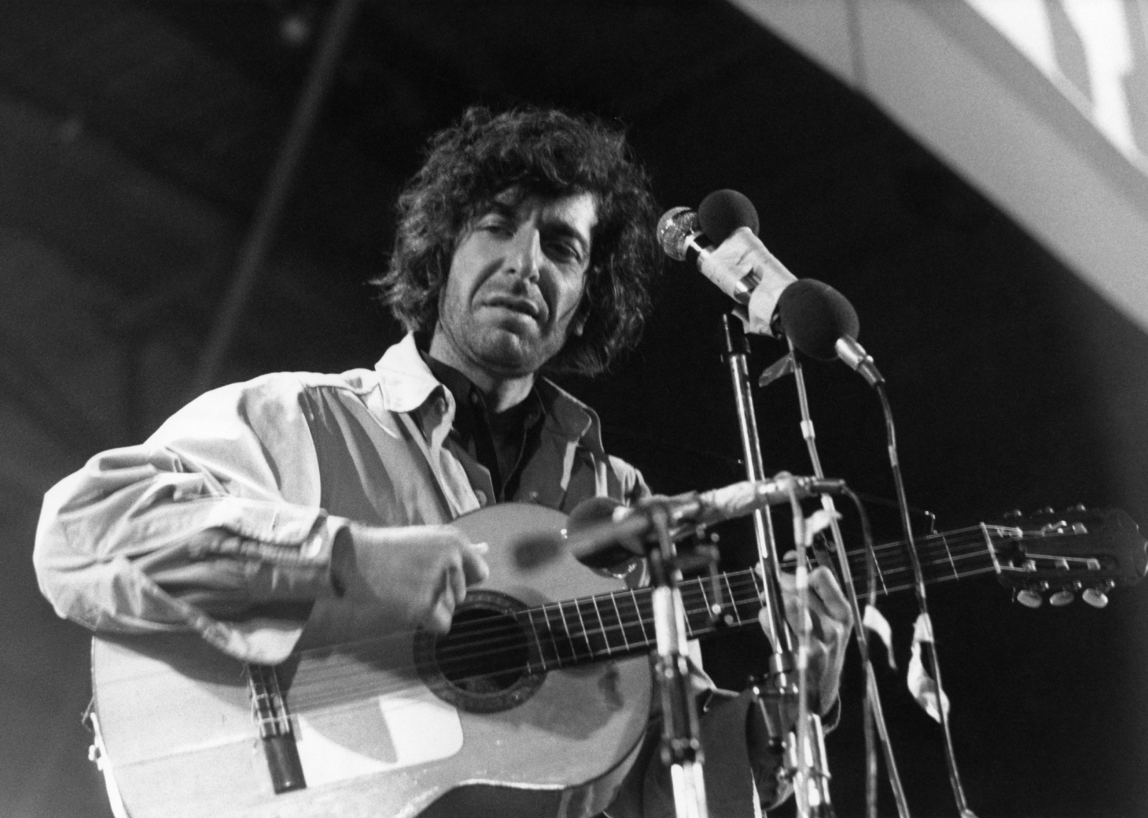 Leonard Cohen performing onstage.