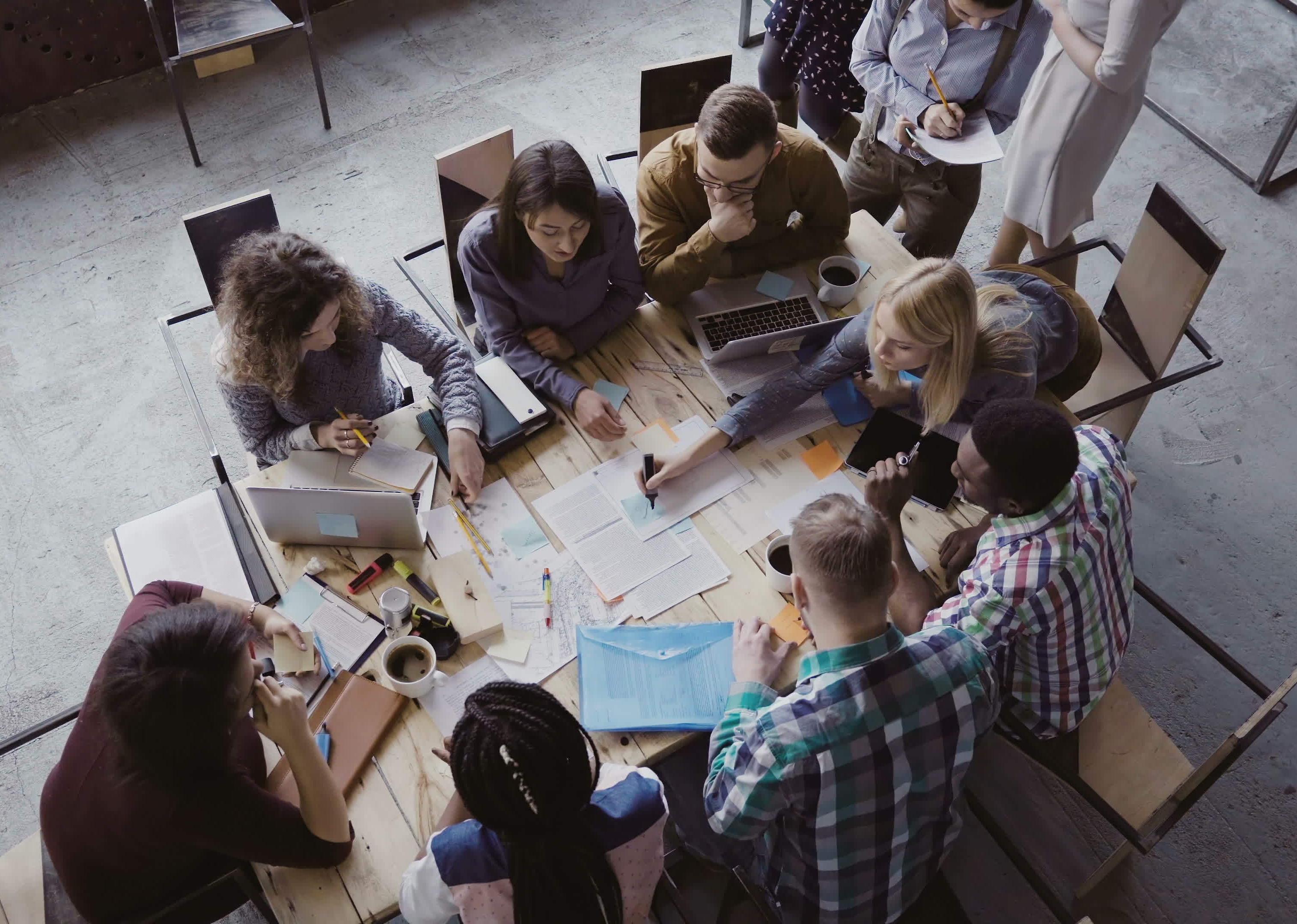 A group of people sitting around a table working.