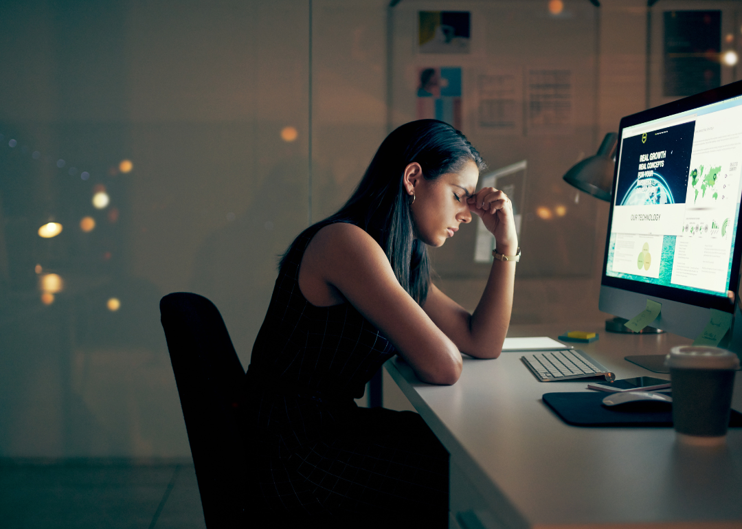 A woman experiencing burnout at a computer.