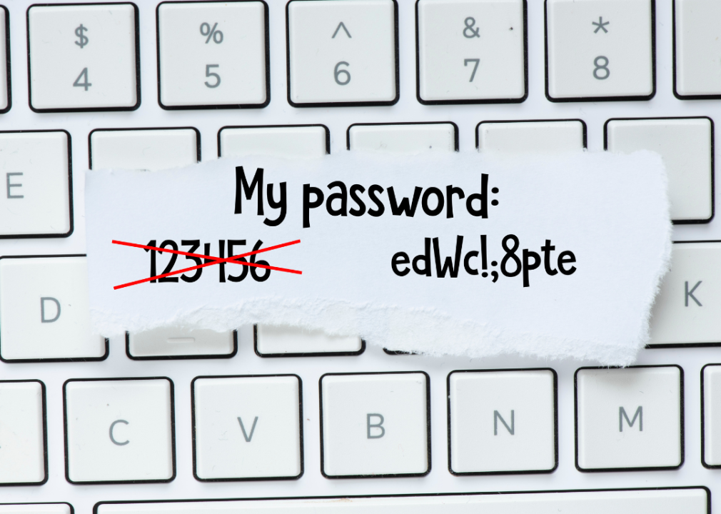 Scrap of paper with a crossed out password and a new one on top of a keyboard.