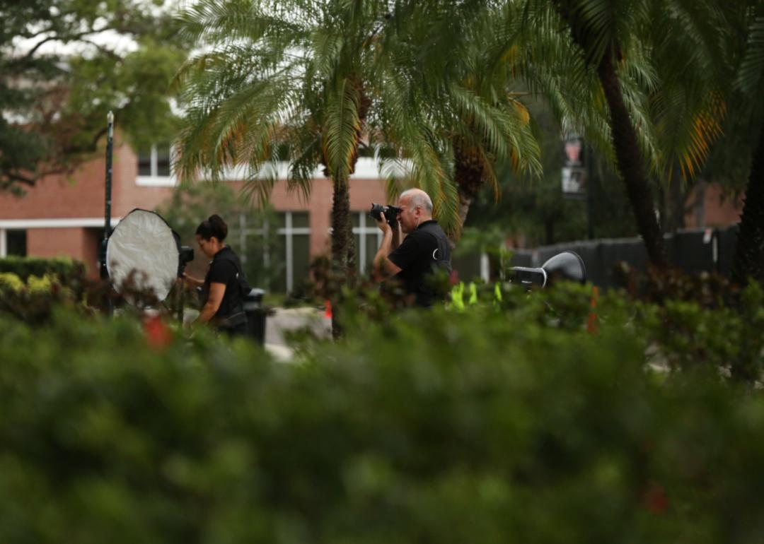 A team of photographers setting up equipment among the palm trees.
