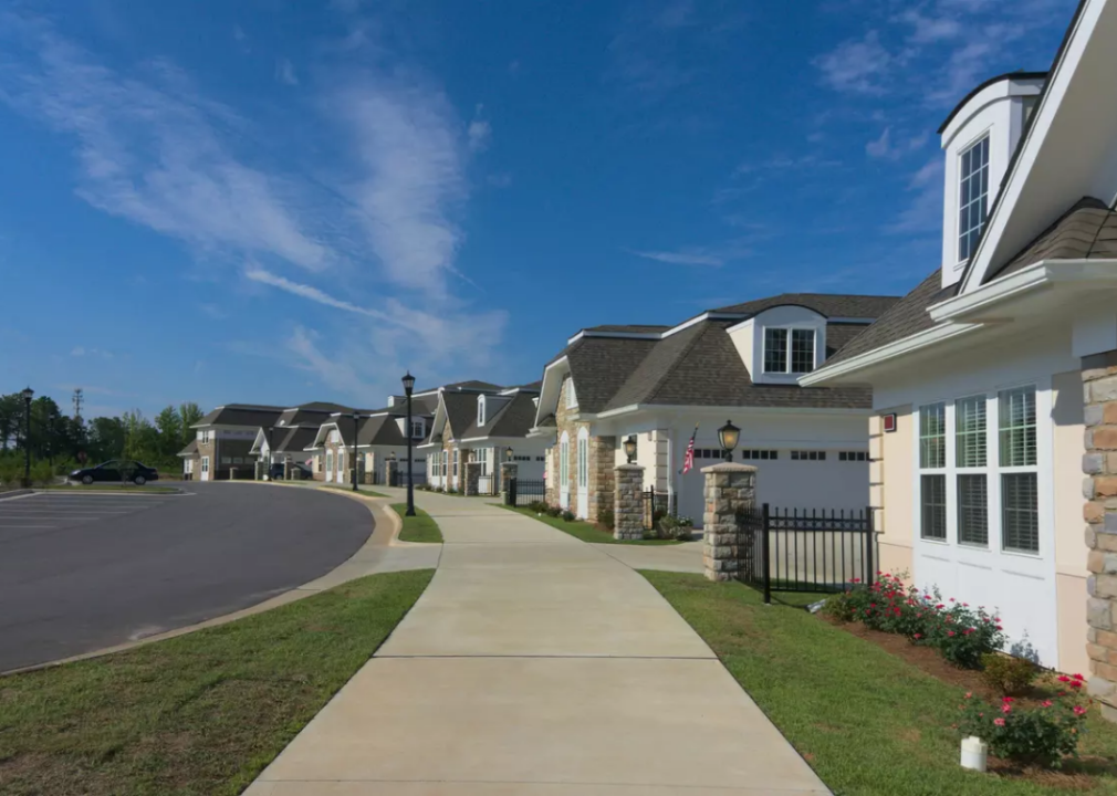 A cul-de-sac of homes with a paved sidewalk. 