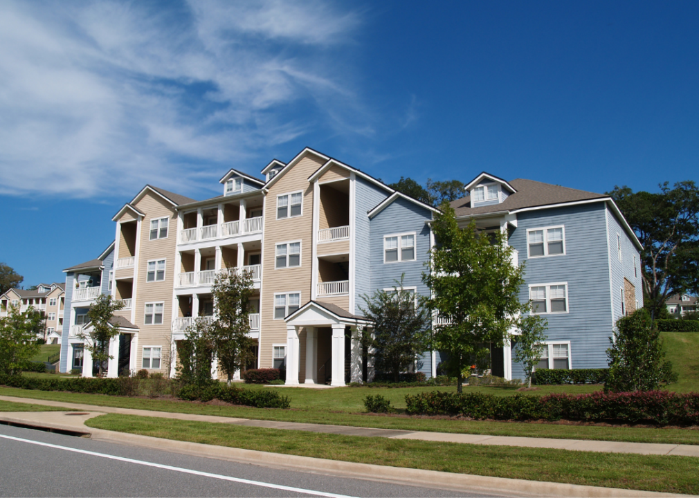 Four and five storey blue and tan apartment buildings.