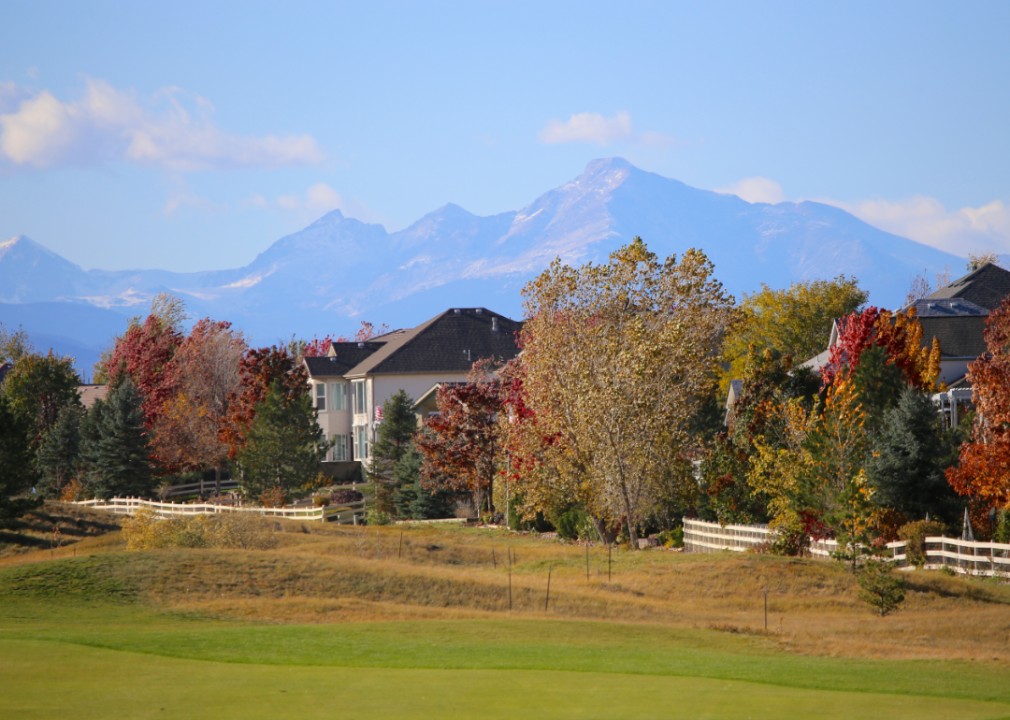 Large homes in autumn with mountains in the background.