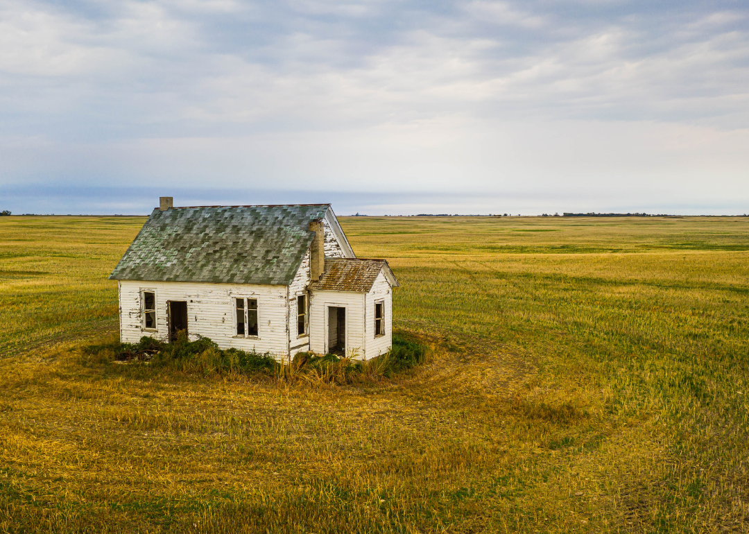 A dilapidated home in a field.