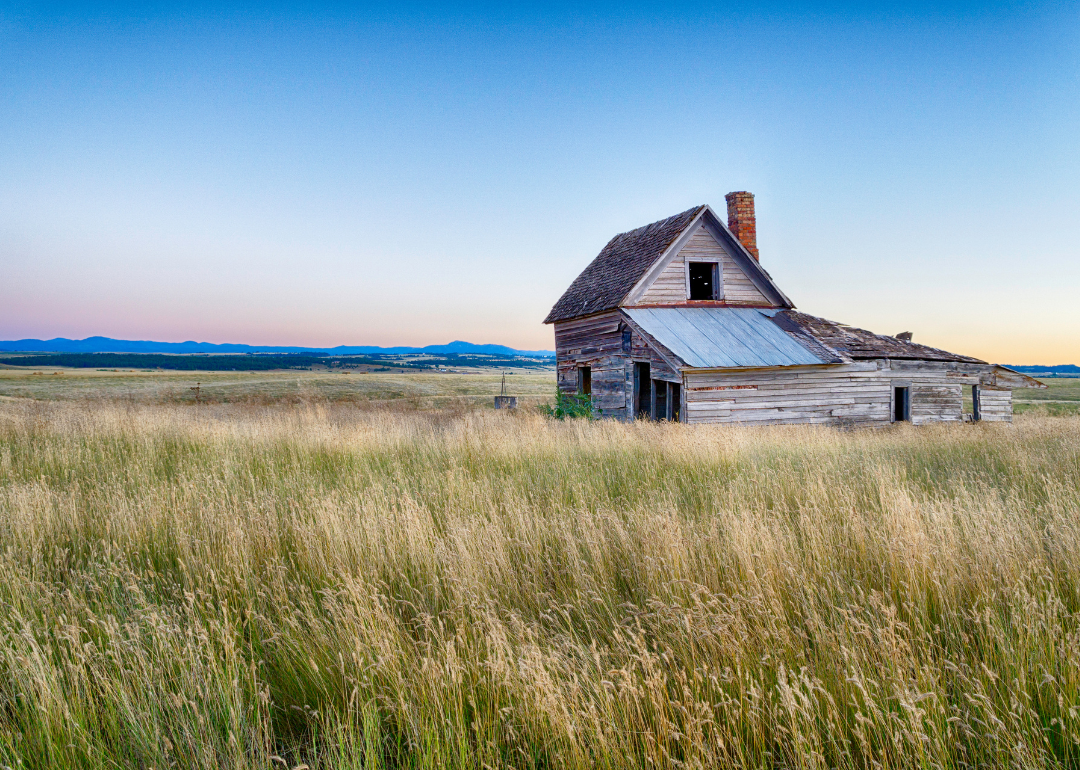 An abandoned ranch house on a prairie.
