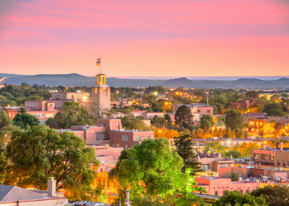Pink and orange buildings and lights match the sunset over Santa Fe, New Mexico.