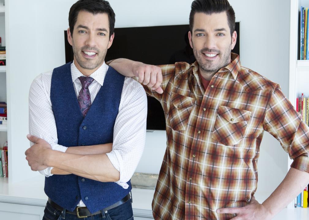 Jonathan and Drew Scott pose together in a living room.