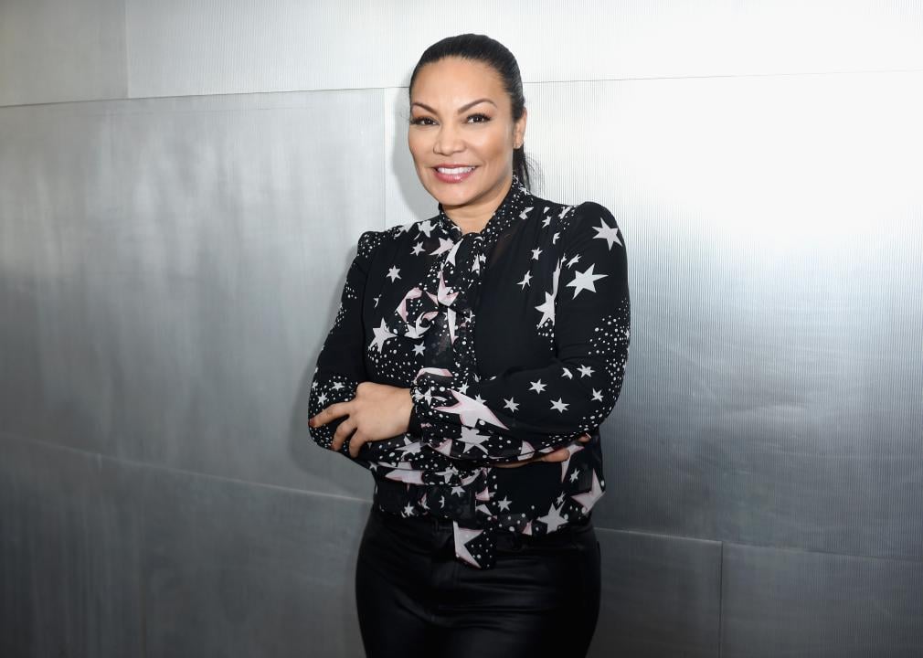 Egypt Sherrod attends the Defining Design at HGTV panel and poses in front of a silver background.