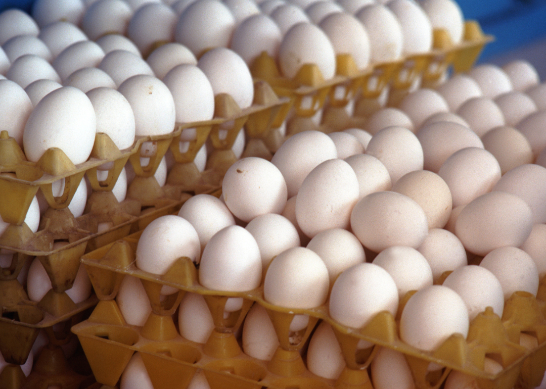 Stacks of white eggs in crates.