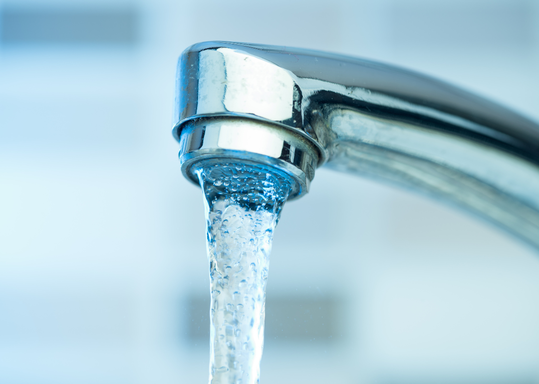 Water pouring out of a silver faucet.