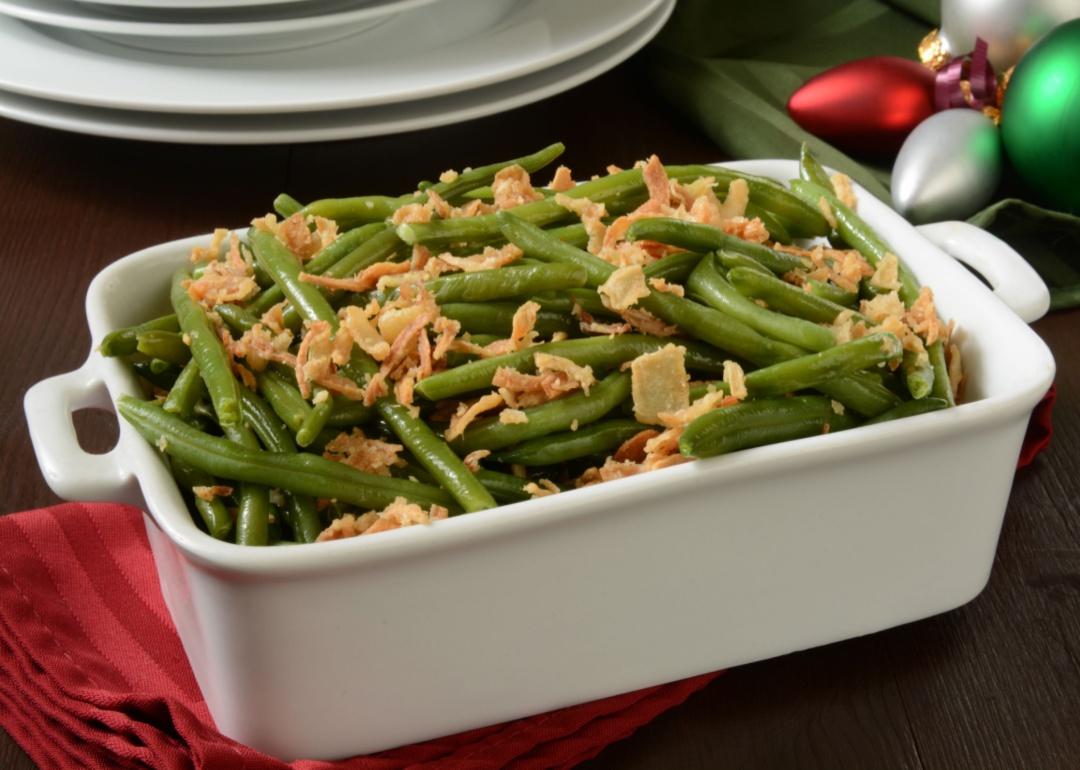 A white baking dish of green bean casserole on a table.