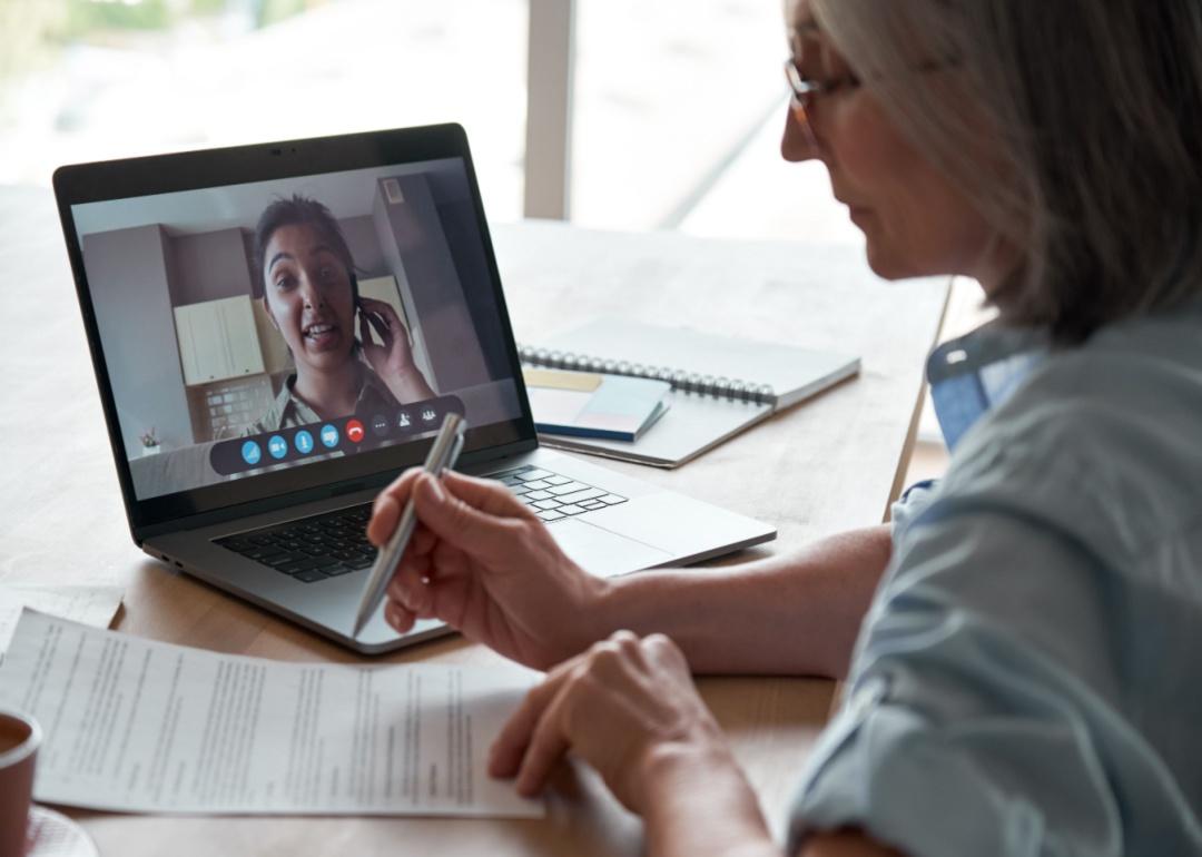 A woman interviewing another woman virtually.