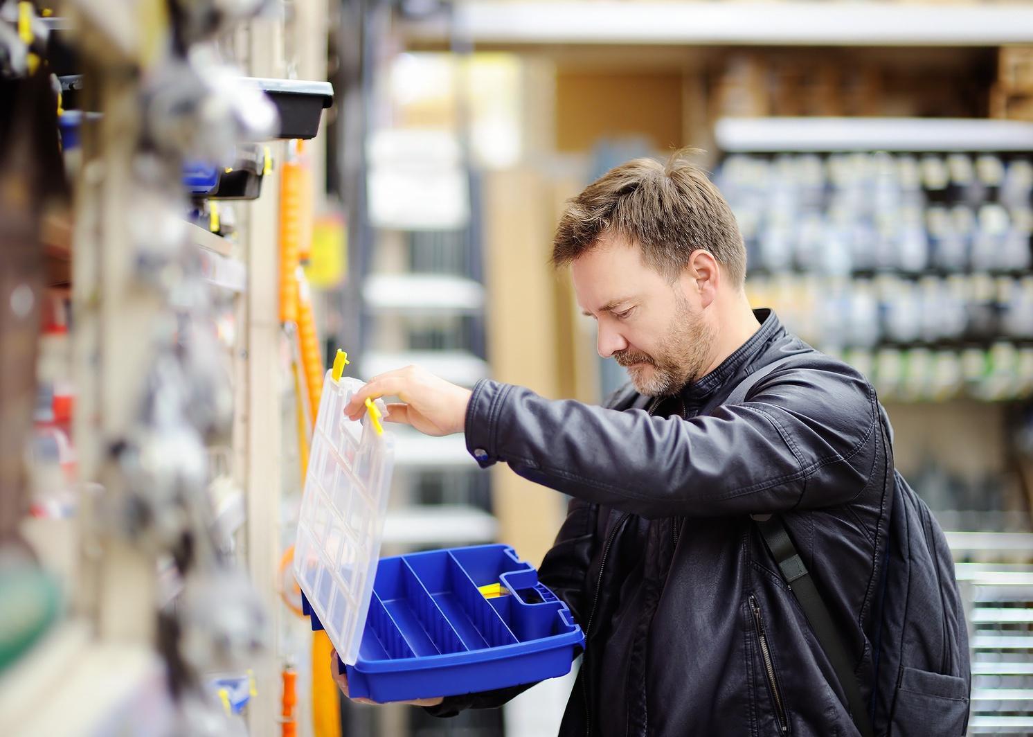 A man looking at a tool box at a home improvement store.