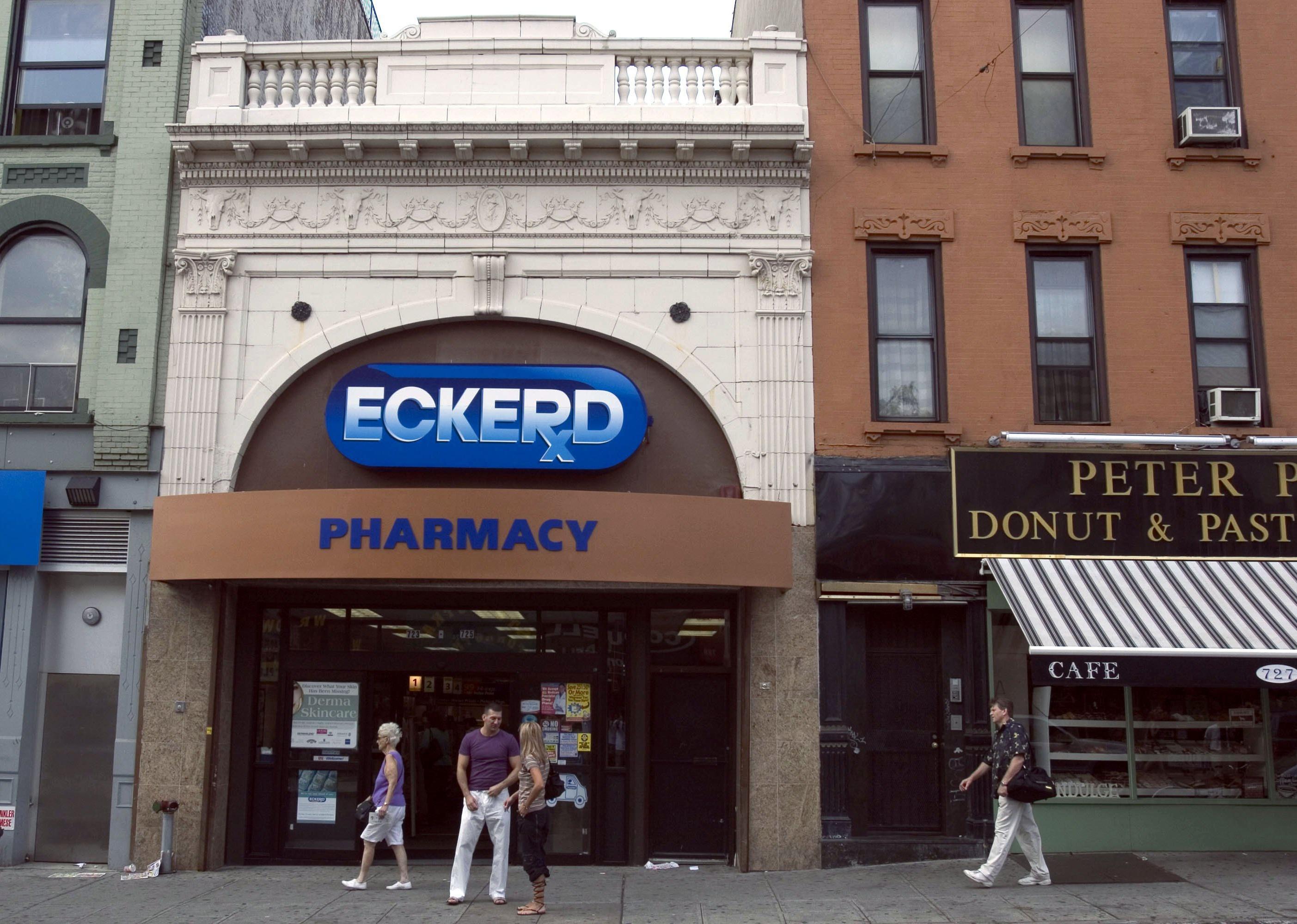 People standing on the sidewalk in front of Eckerd's Pharmacy.
