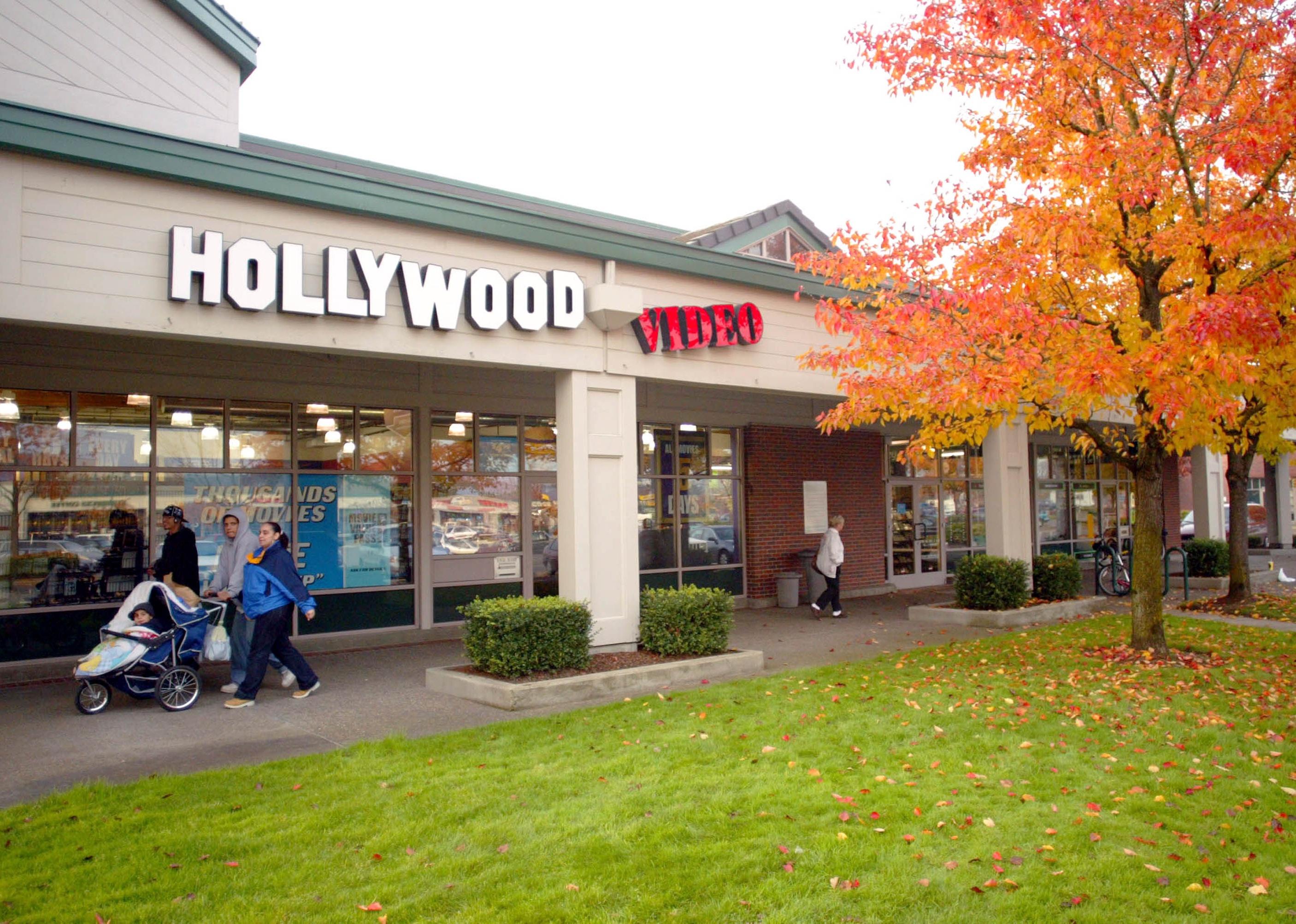 People walking past a Hollywood Video store.
