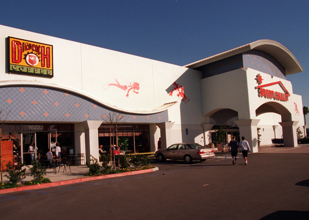 A Sports Chalet entrance and parking lot.