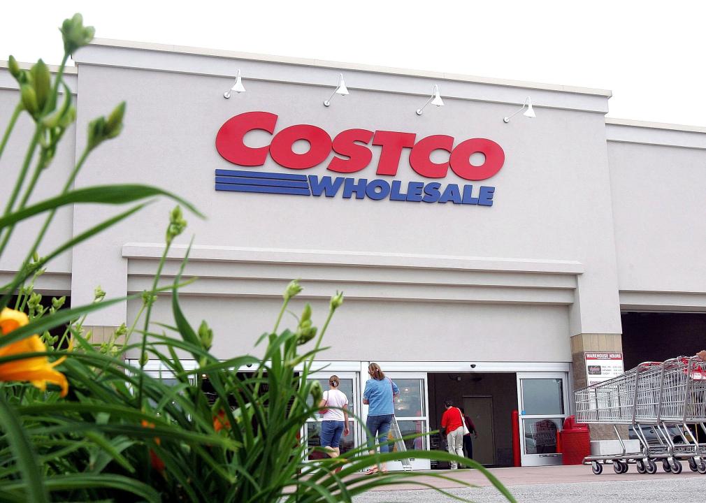 A worker pushes carts outside a Costco store.