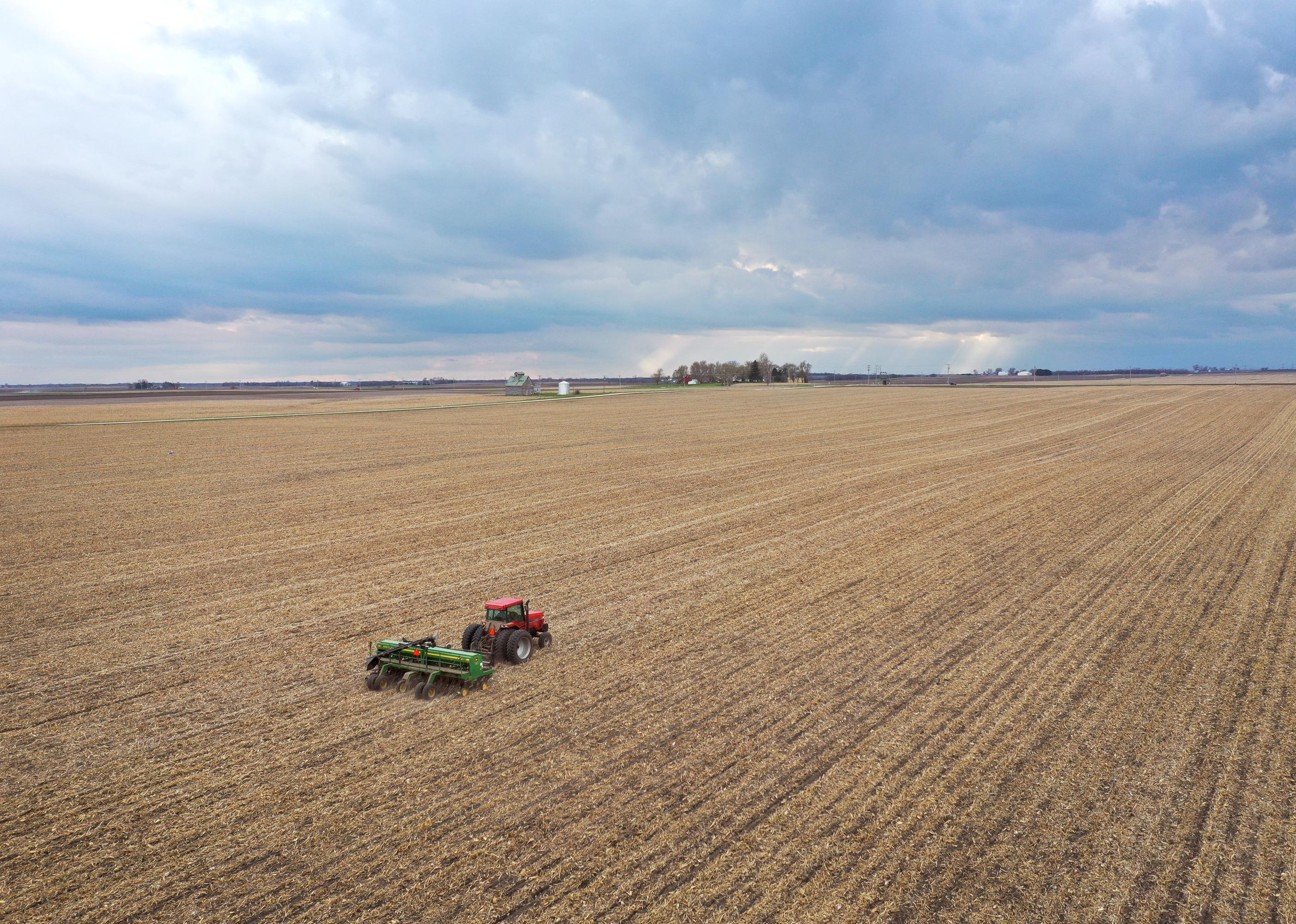 An aerial view of a tractor planting on a field.