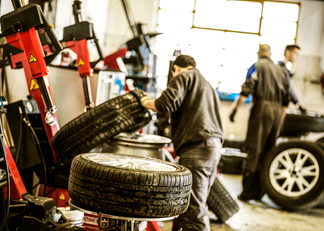 Three guys working on tires at an auto repair shop.