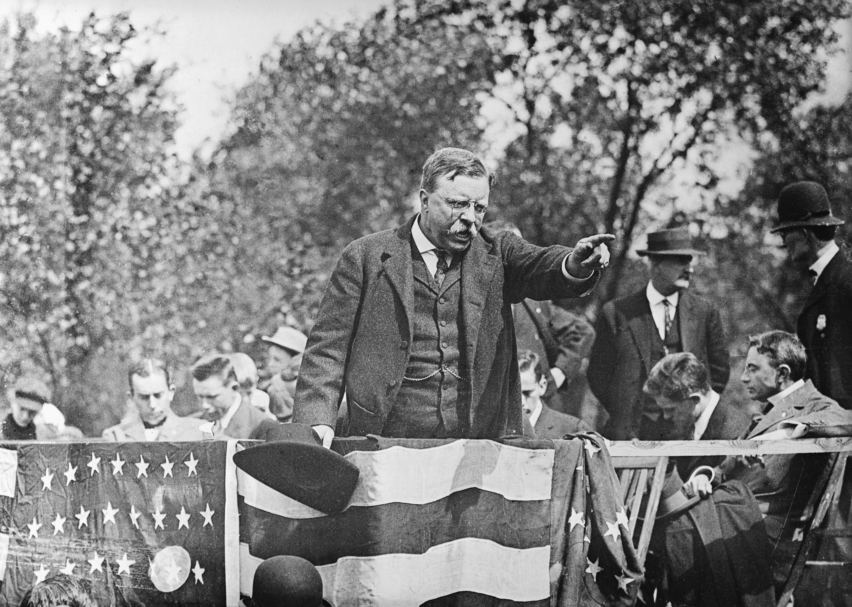 Theodore Roosevelt giving a campaign speech onstage.
