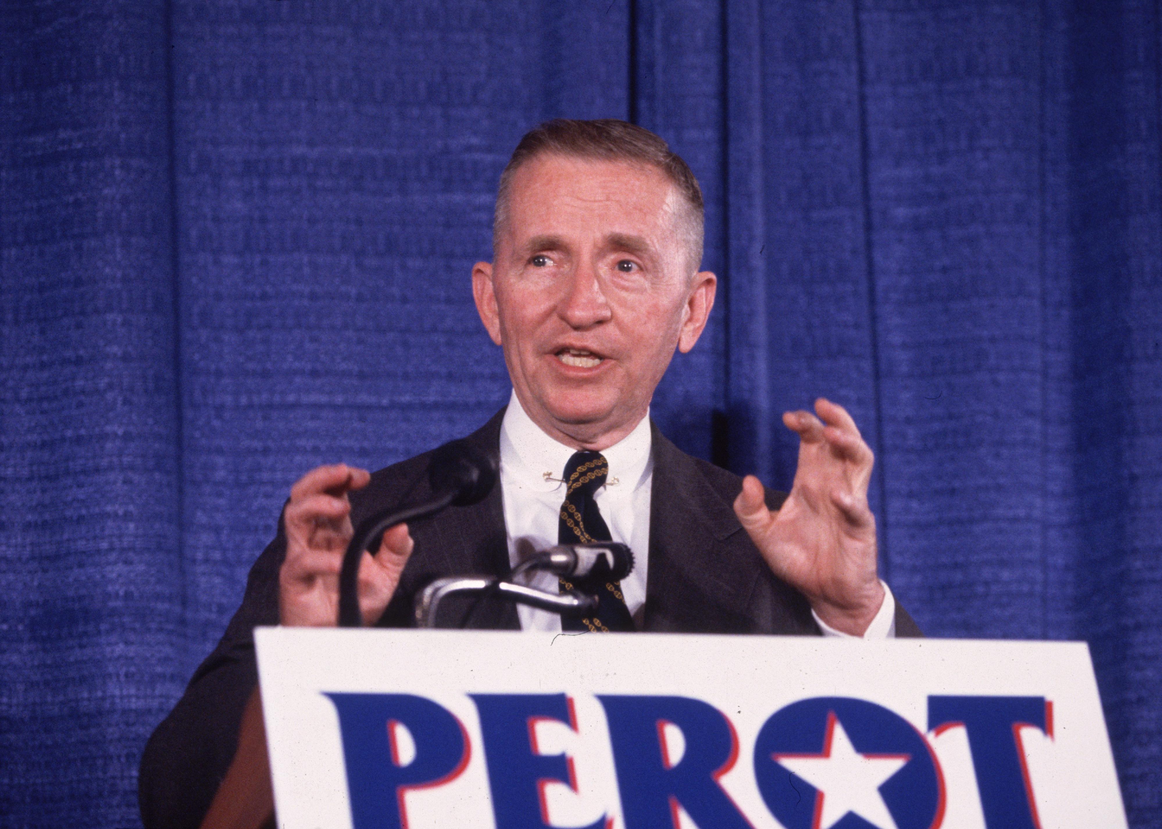 Ross Perot giving a speech onstage.