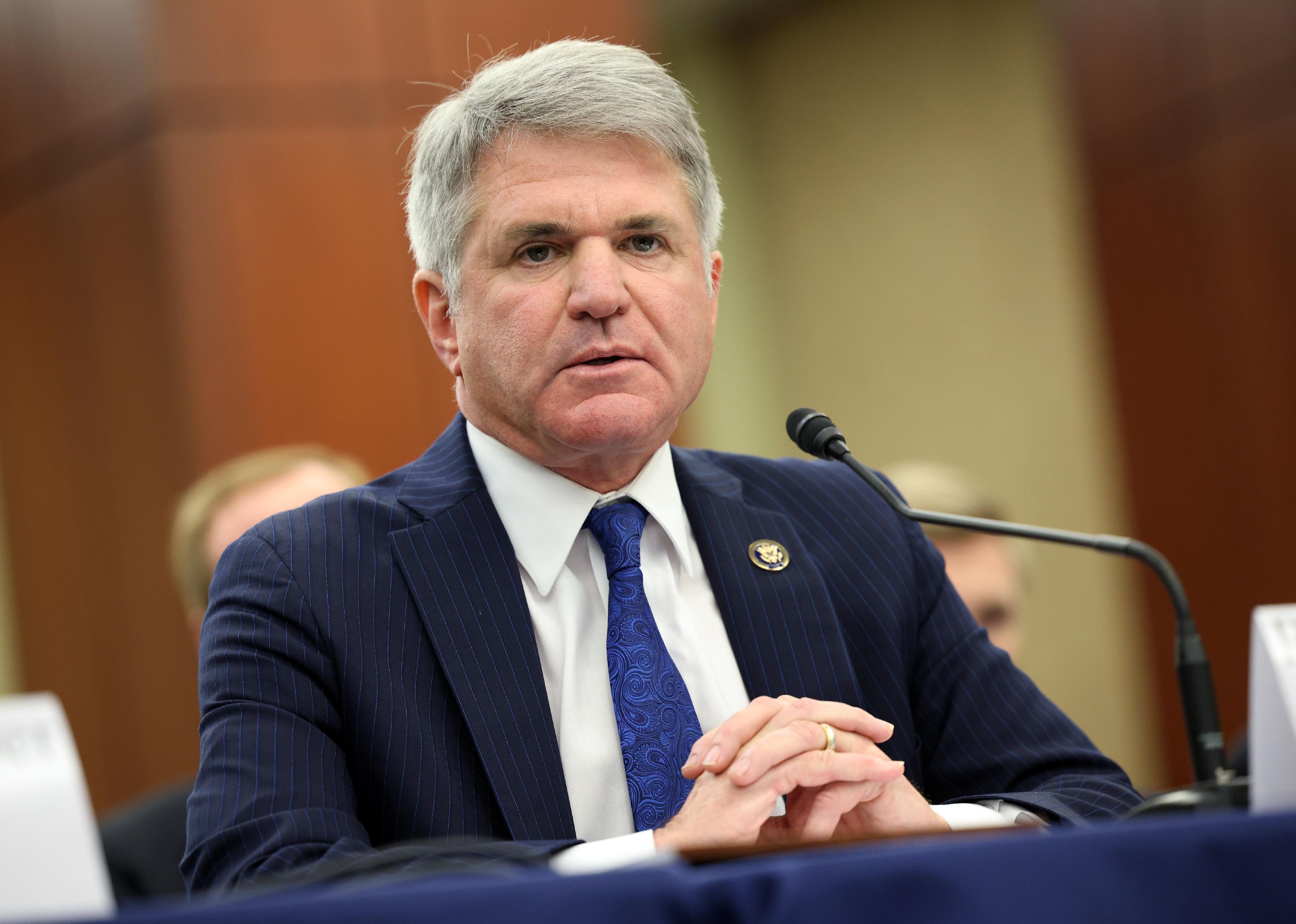 Michael T. McCaul, wearing a dark suit and blue paisley tie, speaking into a microphone.