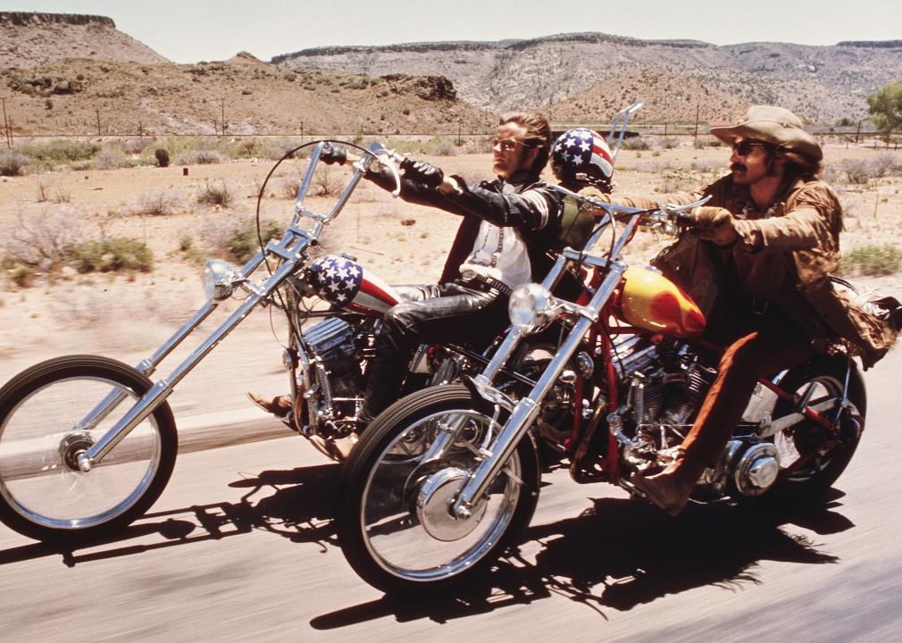 Dennis Hopper and Peter Fonda riding motorcycles on the highway in the desert.