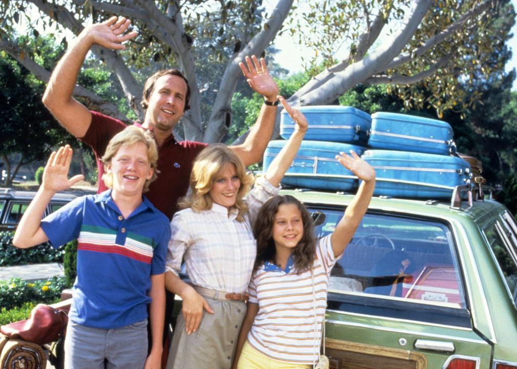 The Griswold family waving in front of their packed up station wagon
