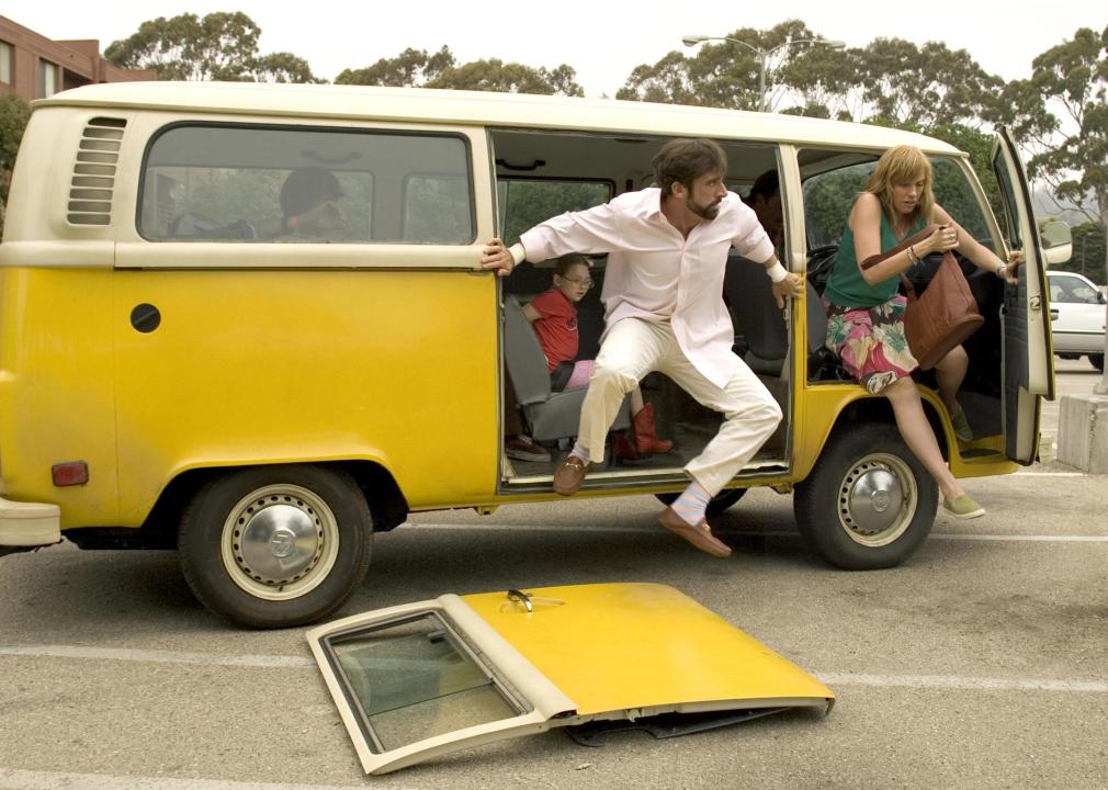 A family bursting out of a yellow VW van with the door on the ground.