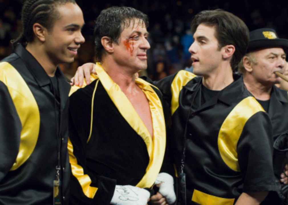 Sylvester Stallone smiles with his character's family after a boxing match.