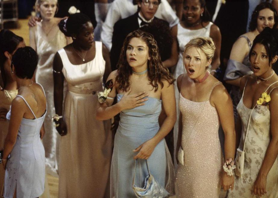 Girls at a 90's prom gasp in surprise.