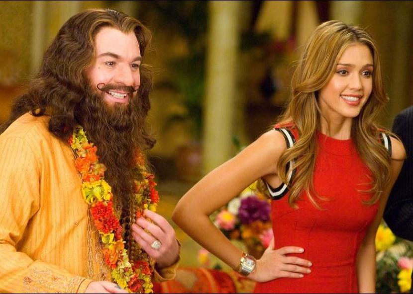 Jessica Alba in a red dress with Mike Myers, who has long hair and a beard.
