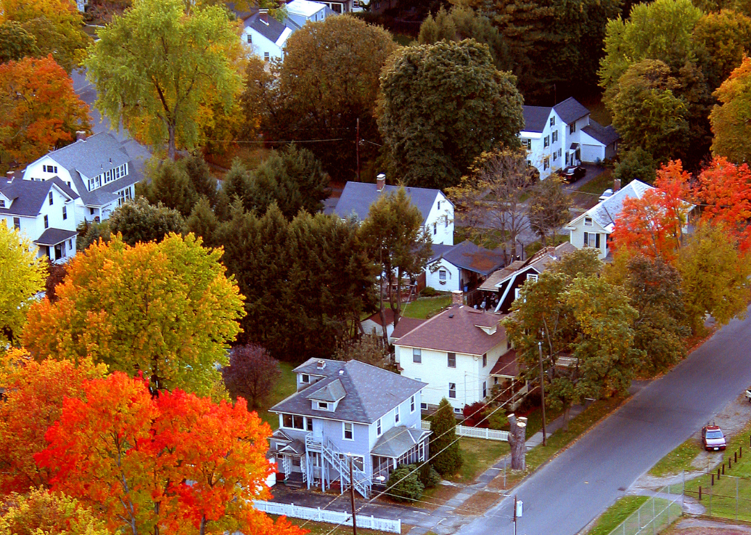 Aerial view of homes surrounded by colorful fall trees.